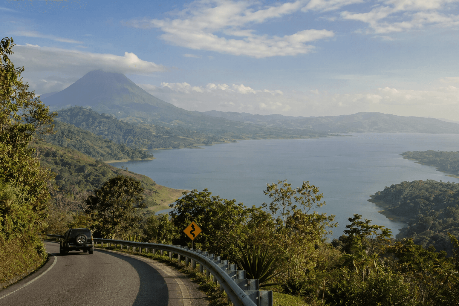 Mountain road overlooking Lake Arenal with Arenal Volcano